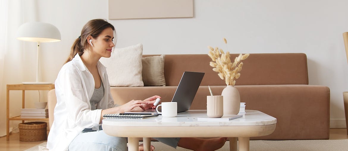 Woman using a laptop in her living room.