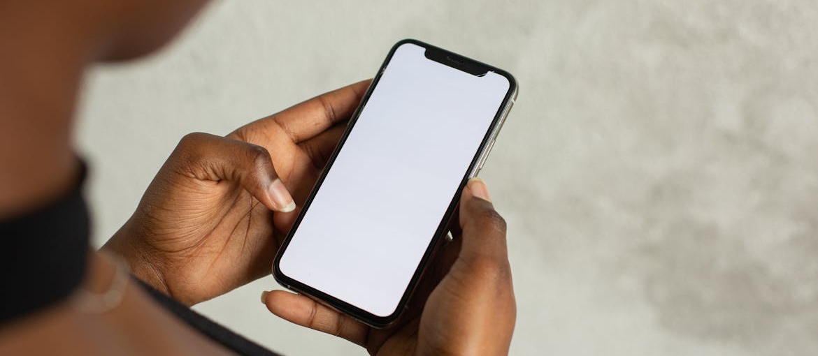 Person holding a phone and looking at a blank phone.