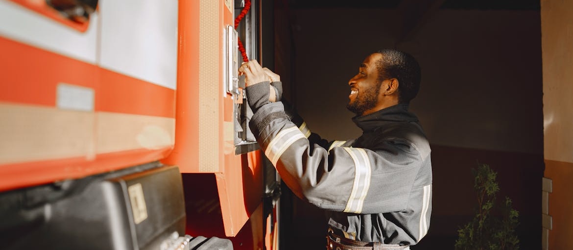 Firefighter standing next to a firetruck.