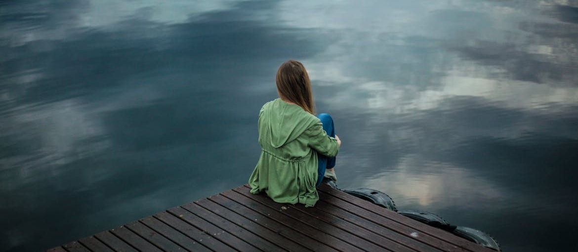 Woman isolating herself on a dock.