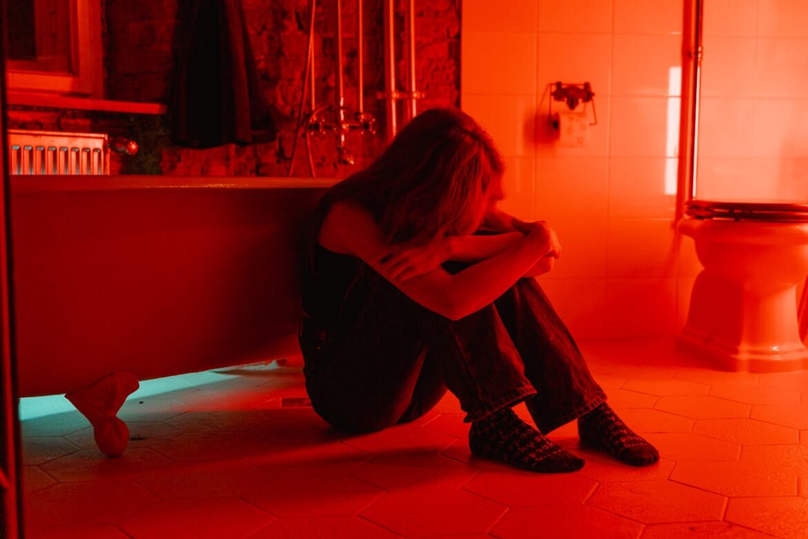 Woman sitting next to a bathtub.