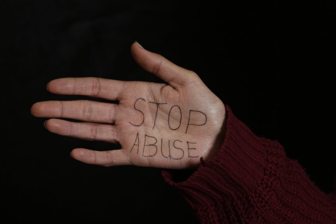 Hand with 'stop abuse' written on it.