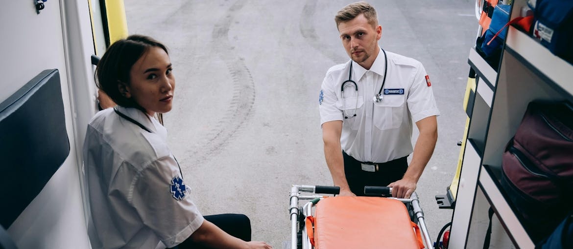 Two medical first responders in the back of an ambulance.