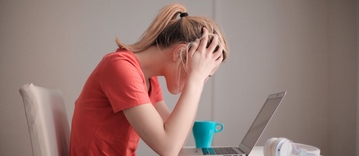 Girl looking at her laptop and worrying about navigating college life in recovery.