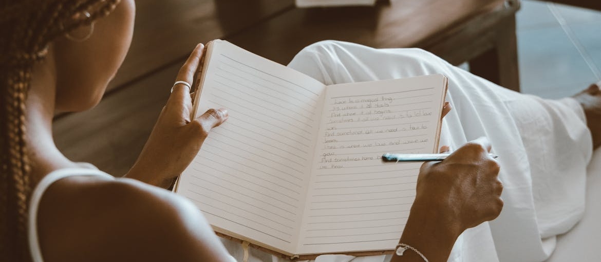 Woman journaling about the struggles of navigating college life in recovery.