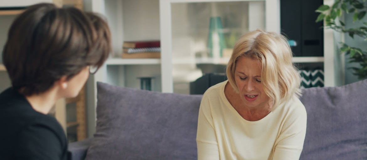 Therapist discussing how domestic violence survivors can rebuild safety through recovery with her distressed client.