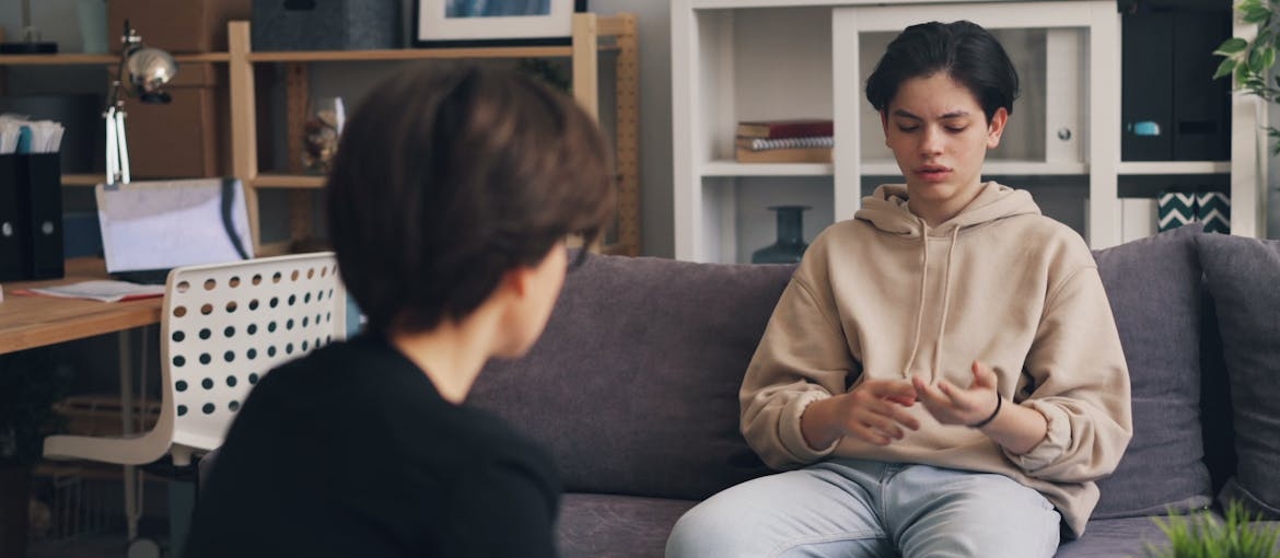 Young student talking about navigating college life in recovery with a college counselor.