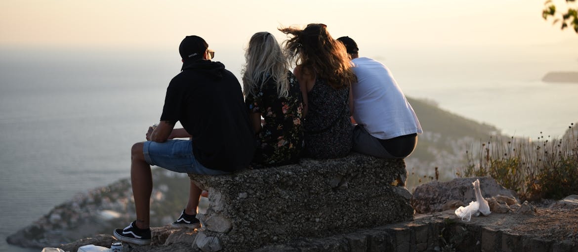 Four friends sitting on a bench.