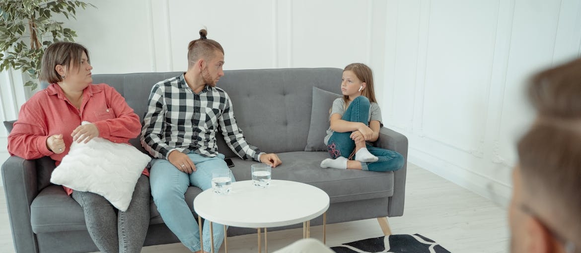 Family sitting on a couch in a therapist's office.