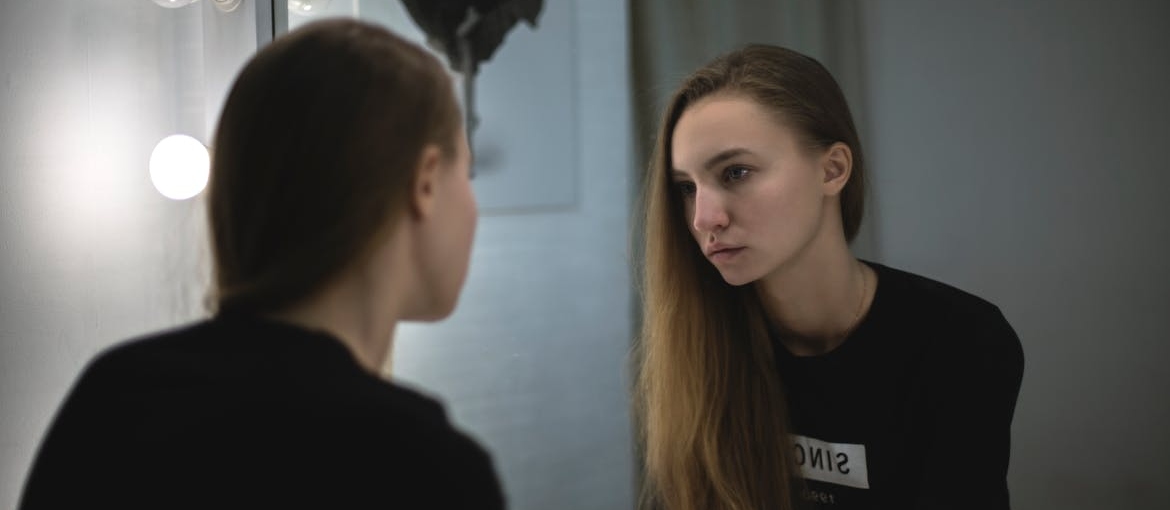 Woman looking at herself in the mirror.