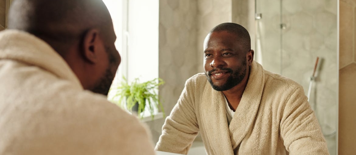 Man saying positive affirmations for recovering addicts to herself in the mirror.
