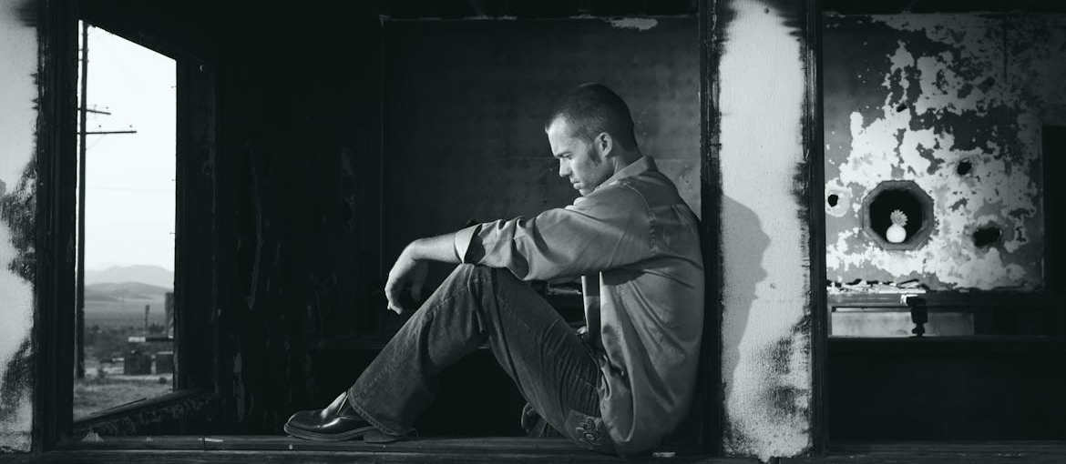 Grayscale picture of a sad man.