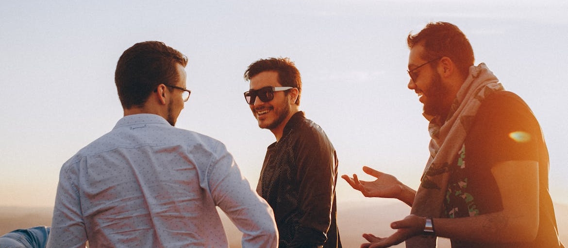 Three friends laughing and masking trauma with humor.