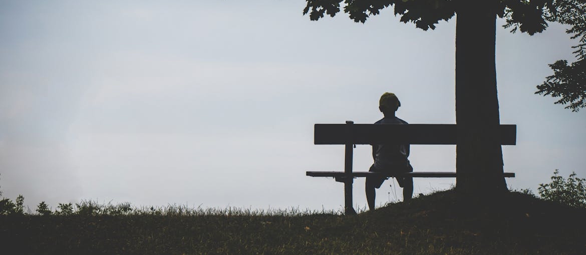 Man sitting on the bench by himself.