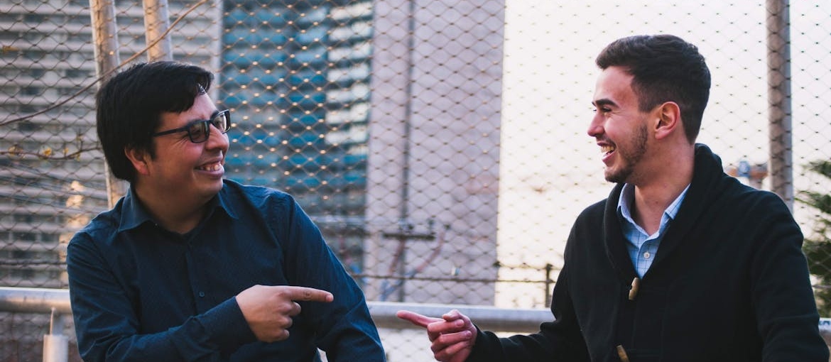 Older and younger man laughing with each other.