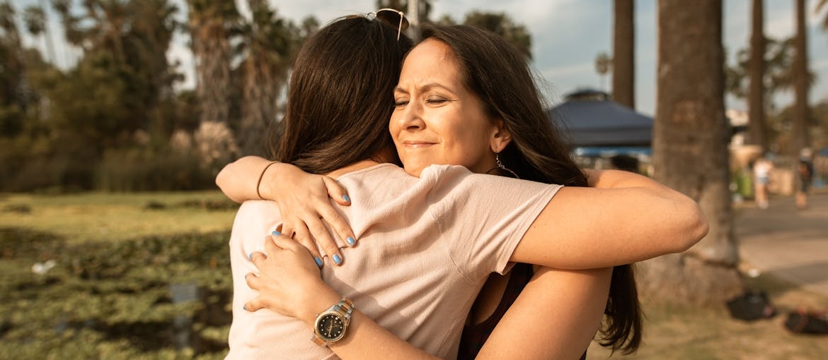 Two women hugging each other.
