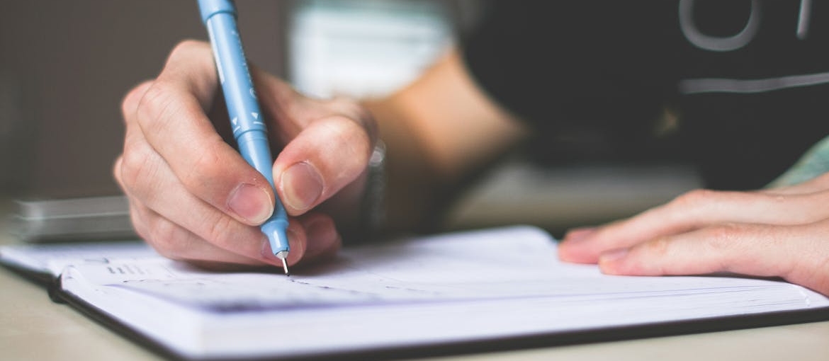 Person writing in a notebook.