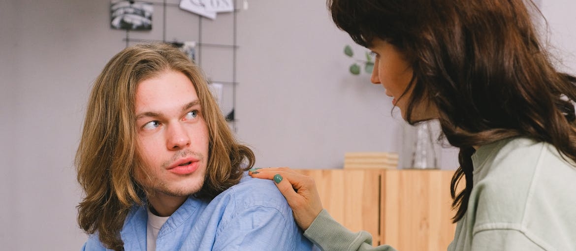 Woman supporting a man who is masking trauma with humor.