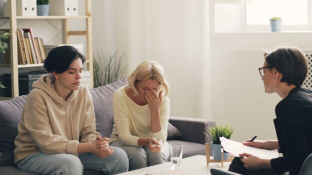 Mother talking about the struggle of being parents of addicts in family therapy.