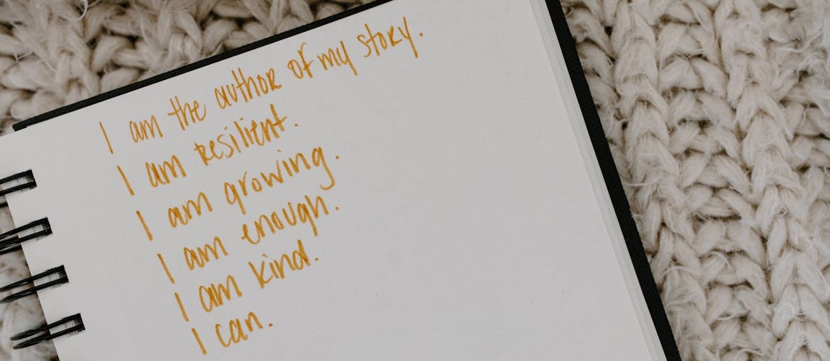 Positive affirmations for recovering addicts written in a notebook.