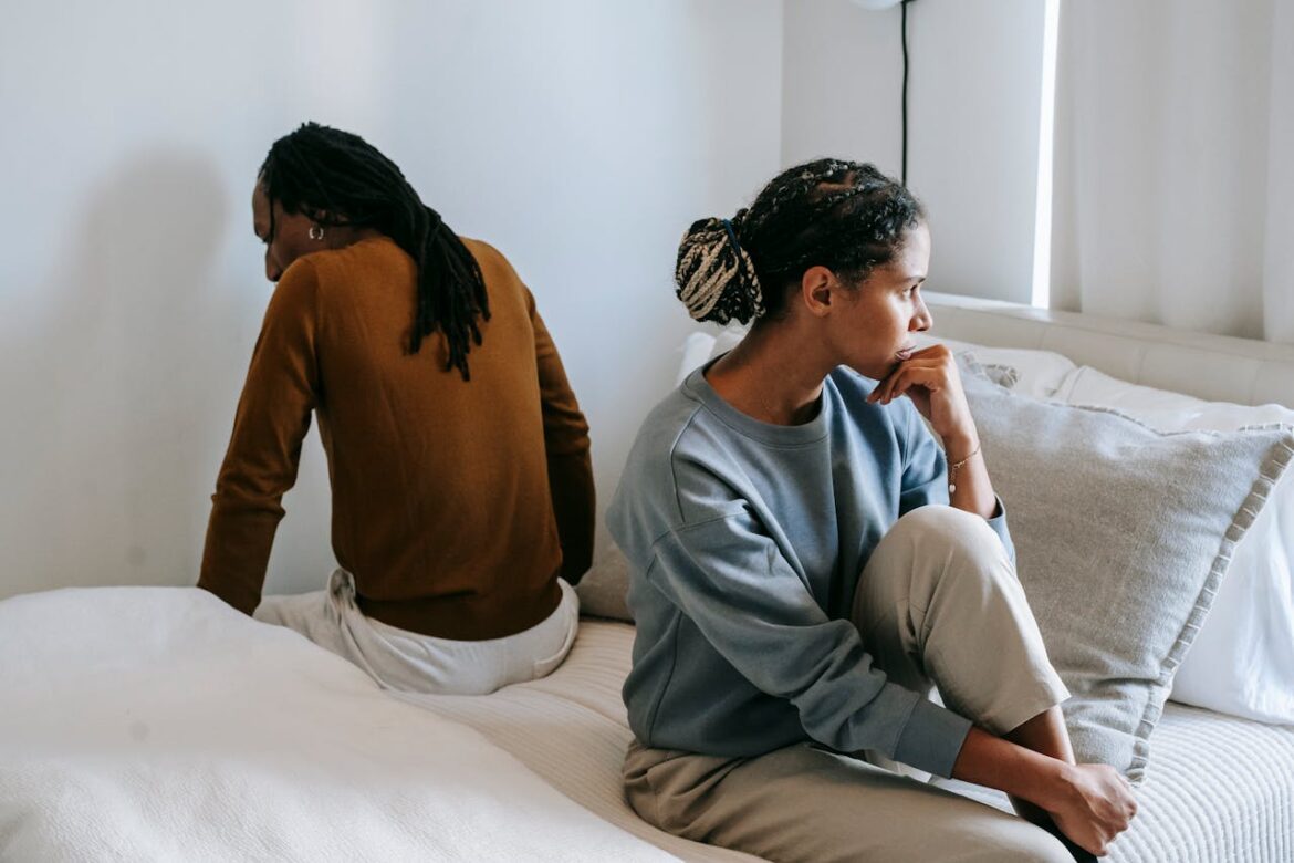Couple sitting on the bed after fighting about addiction and divorce.