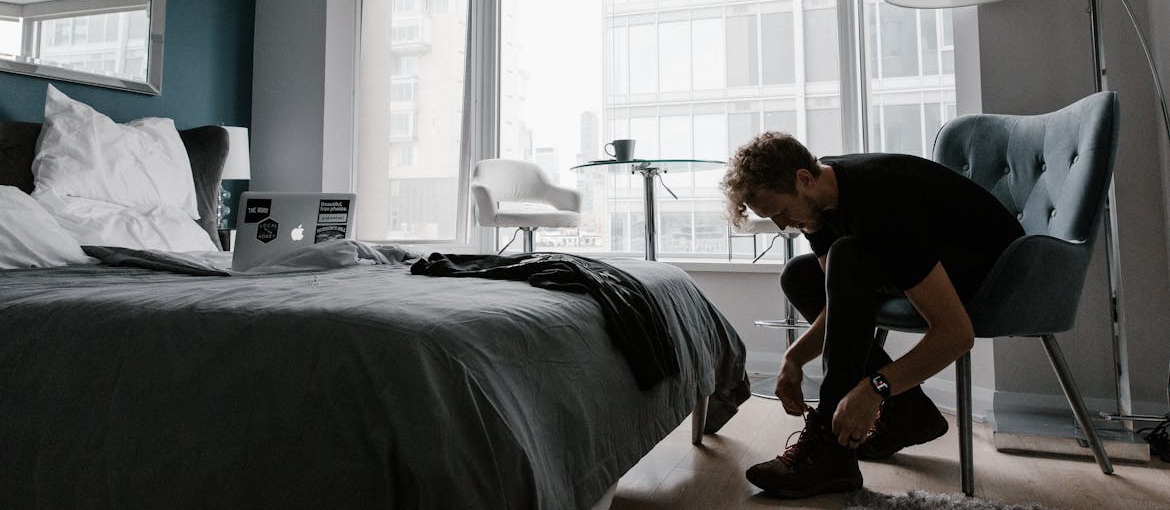 Man tying his shoes before leaving home.