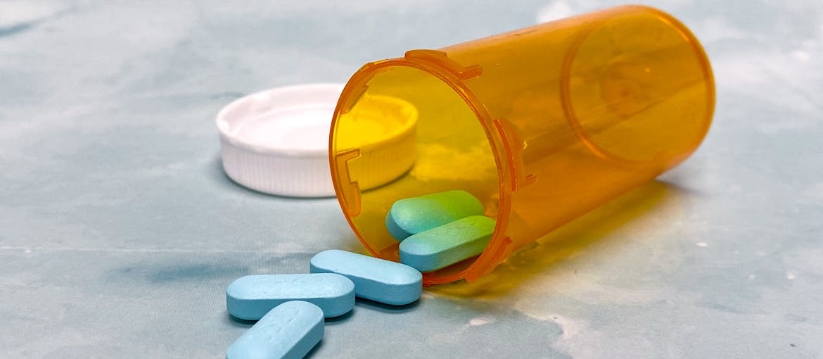 Klonopin pills spilling out of an orange prescription bottle.