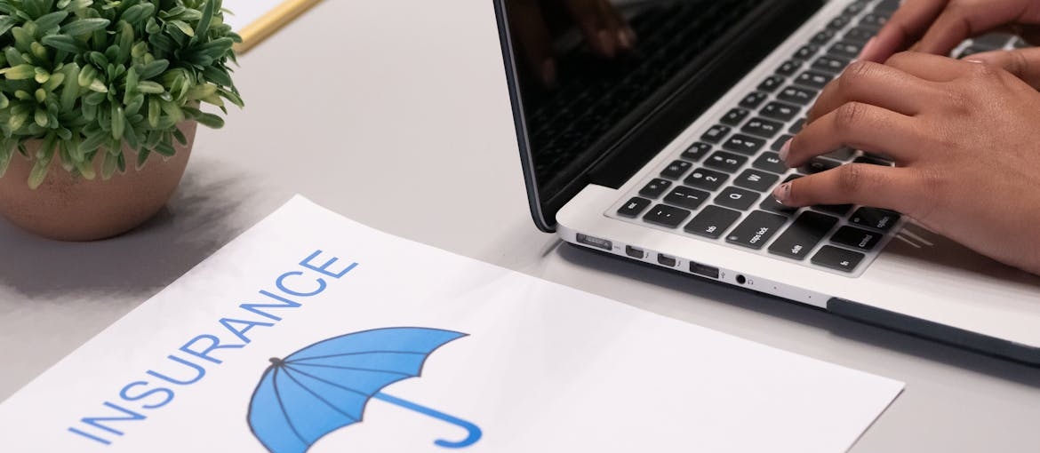 Insurance papers next to a laptop.