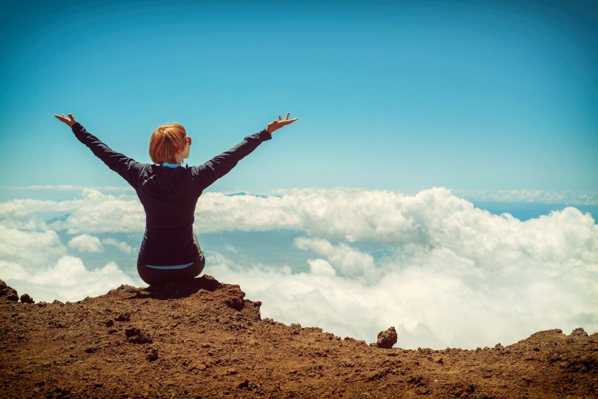 Woman sitting on a cliff and enjjoying life after inpatient rehab.