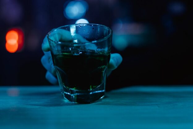 Person holding a whiskey glass.