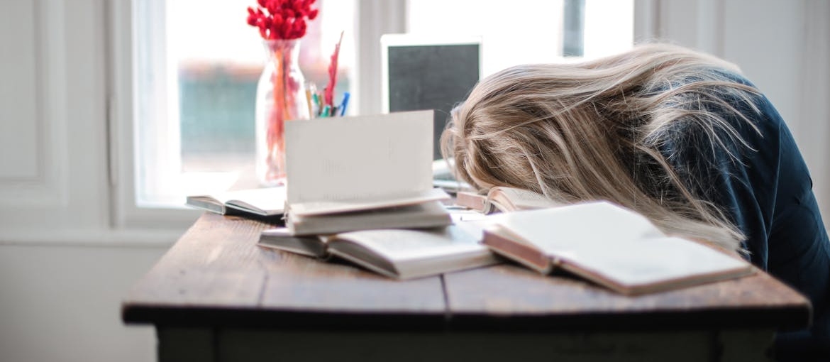 Woman falling asleep on her work desk.