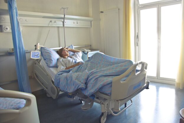 Person lying in a hospital bed.