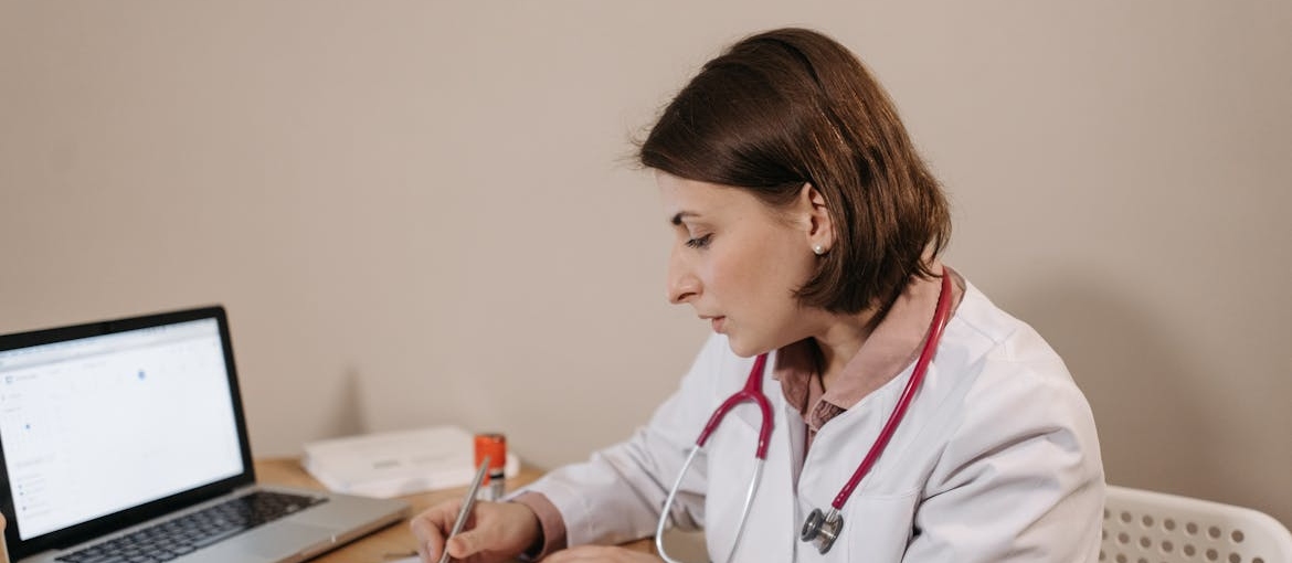 Doctor writing a prescription while talking about gateway drugs.