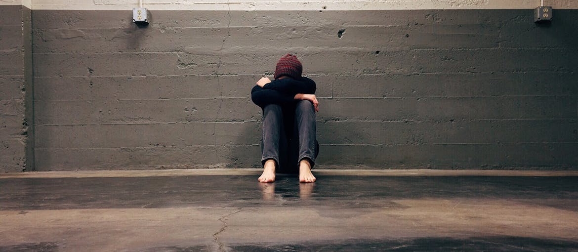Man sitting on the floor while isolating himself.