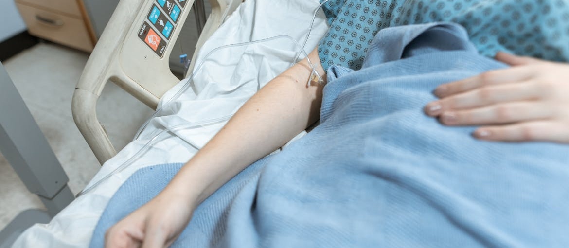 Person lying in a hospital bed.