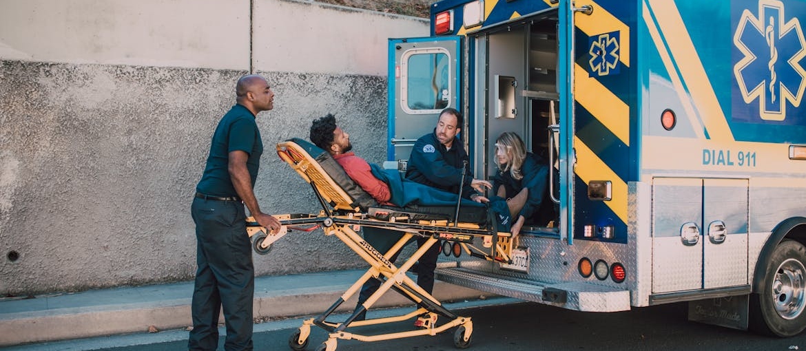 Man on a gurney being put in the back of an ambulance.