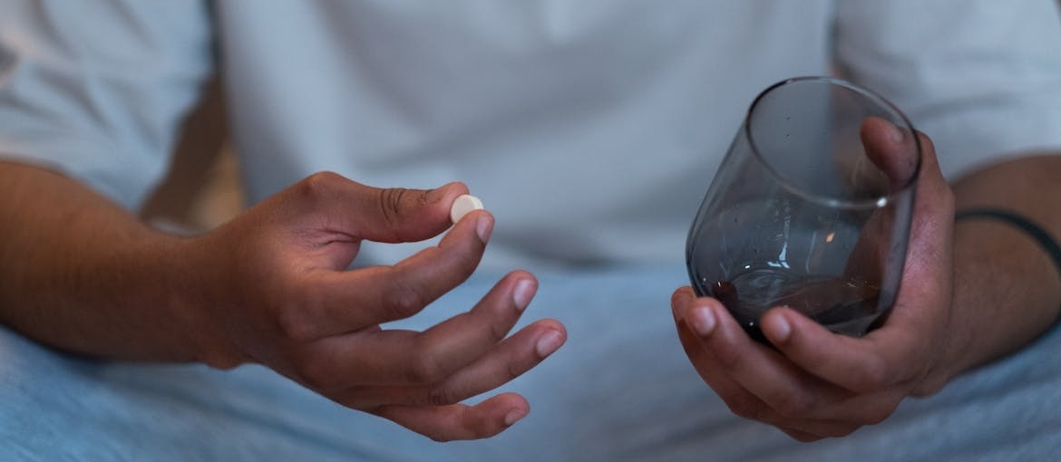 Man holding a Concerta pill and a glass.