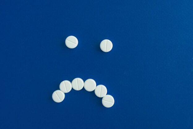 White pills forming a frown.