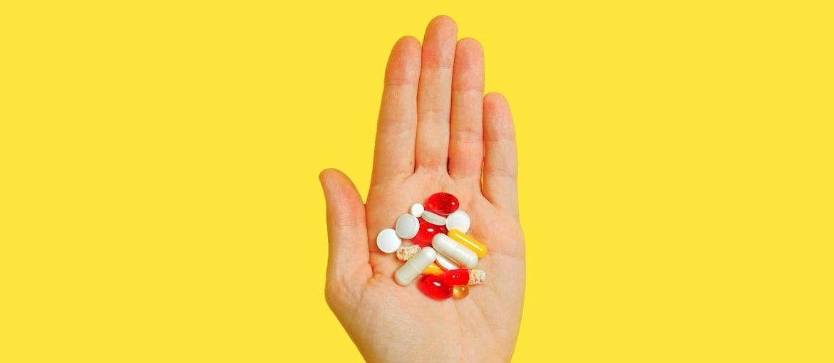 Man holding vitamins in his hand.