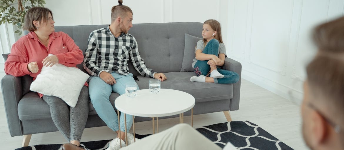 Parents attending family therapy with their daughter.