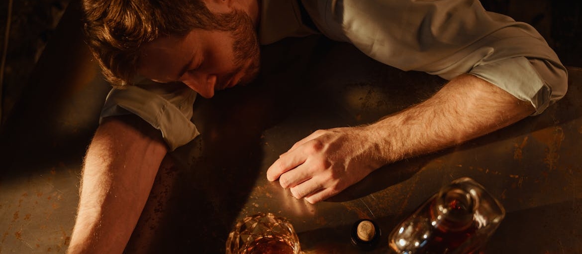 Man lying on a table and going through alcohol poisoning.
