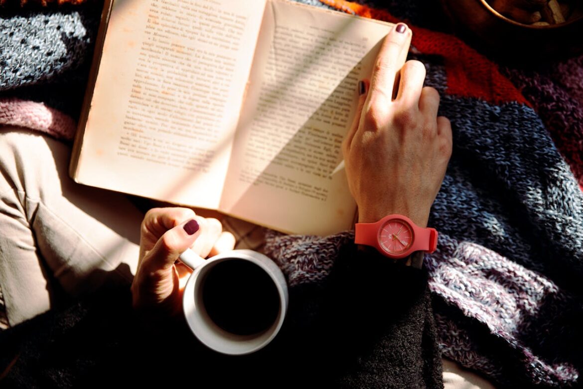Person reading best stress management books and drinking coffee.