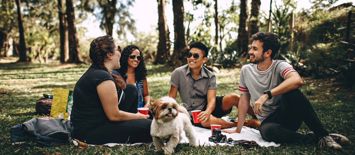 Group of friends sitting in a park and talking.