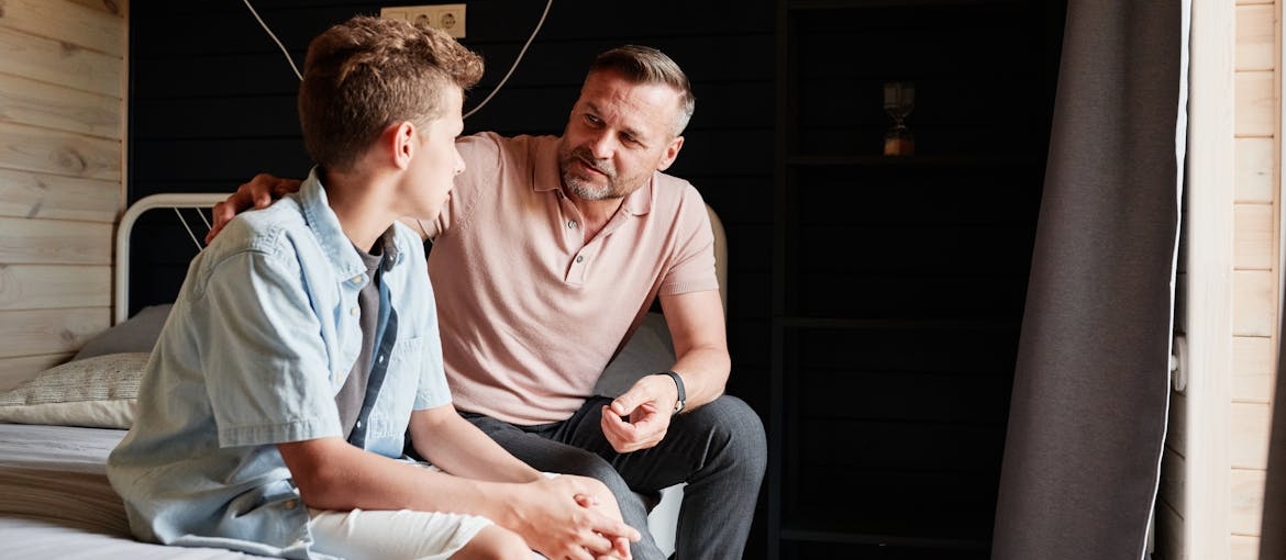 Man supporting a teenage boy.