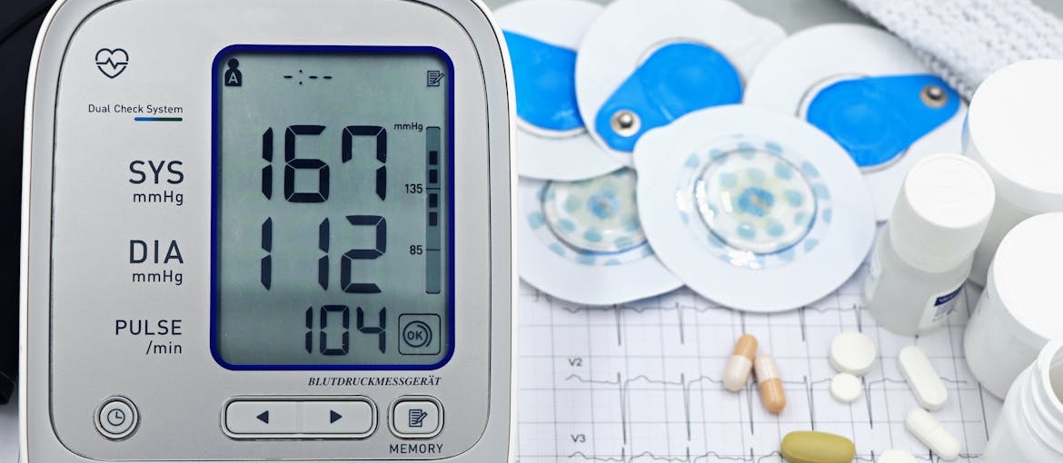 Blood pressure monitor next to pills.