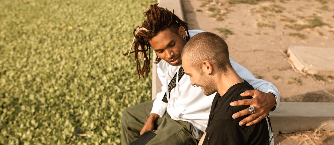 Friends sitting on the ground and having an honest conversation about boundaries.