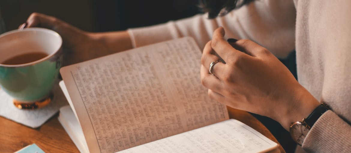 Woman drinking tea and journaling.