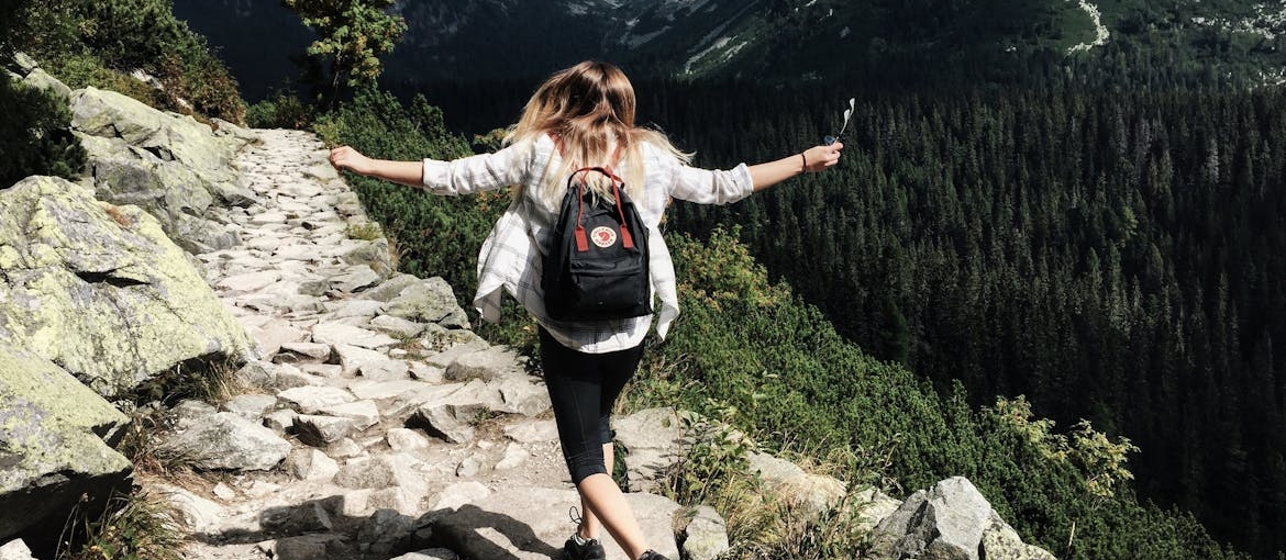 Woman hiking up a mountain.