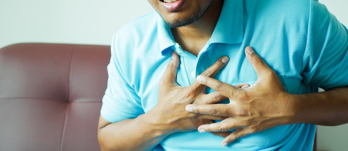 Man holding his hands over his chest.