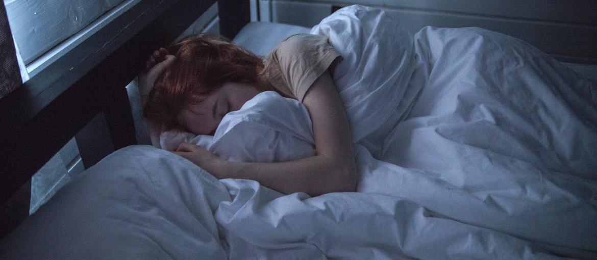 Woman sleeping in a dark room.